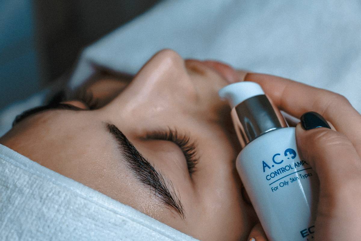 Woman applying b fresh body serum to damp arms after shower for deep hydration